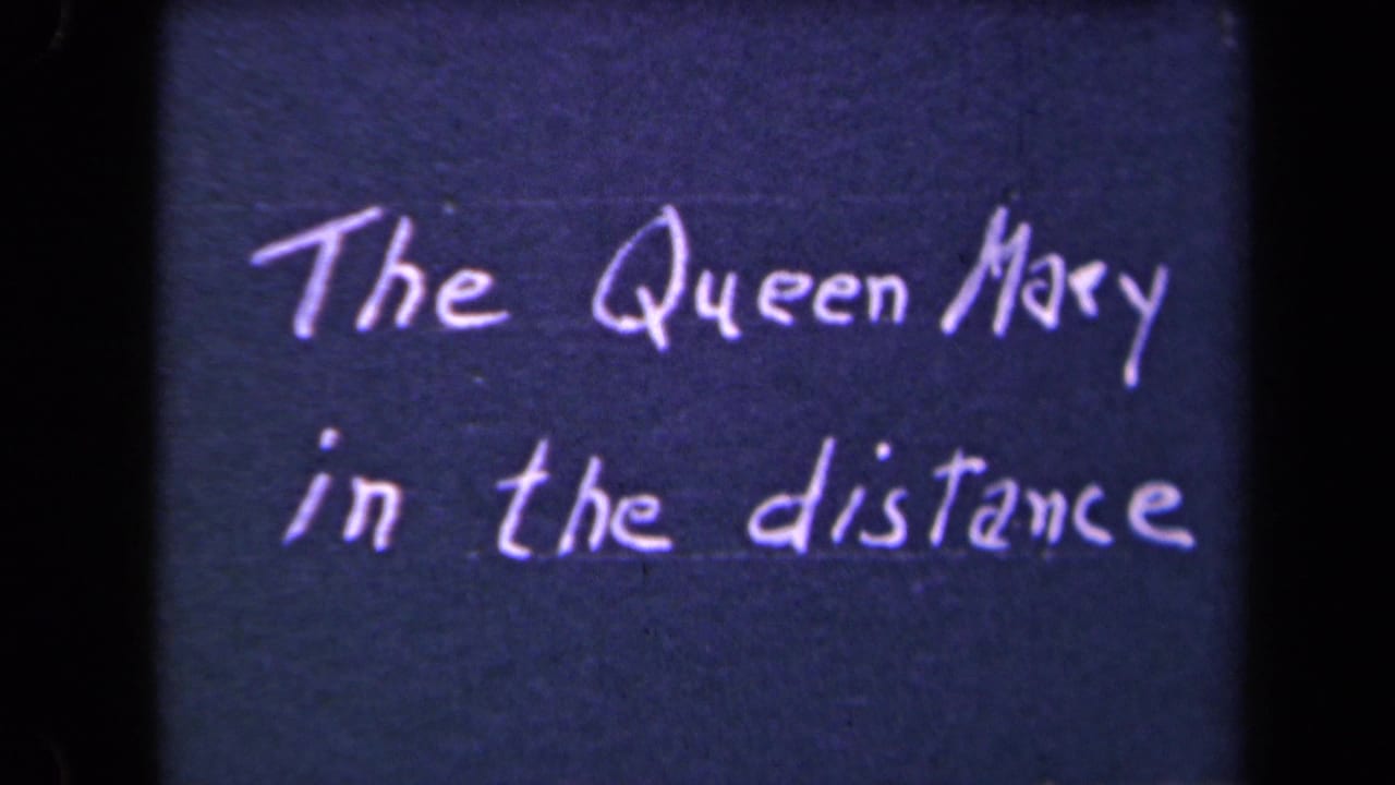 Dark 8mm title card with white script text reading The Queen Mary in the distance.