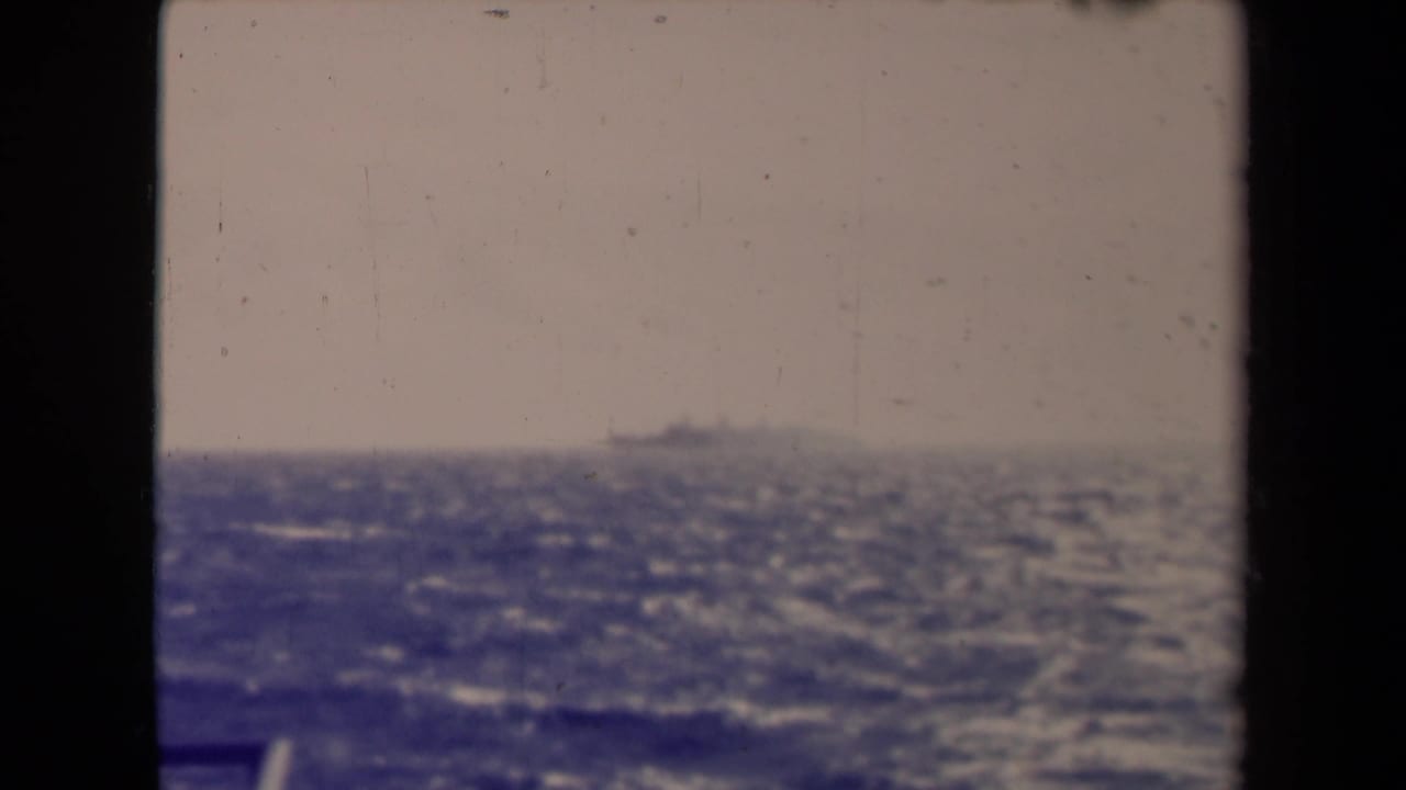 Open sea and horizon with a faint ship beyond a dark vertical support.
