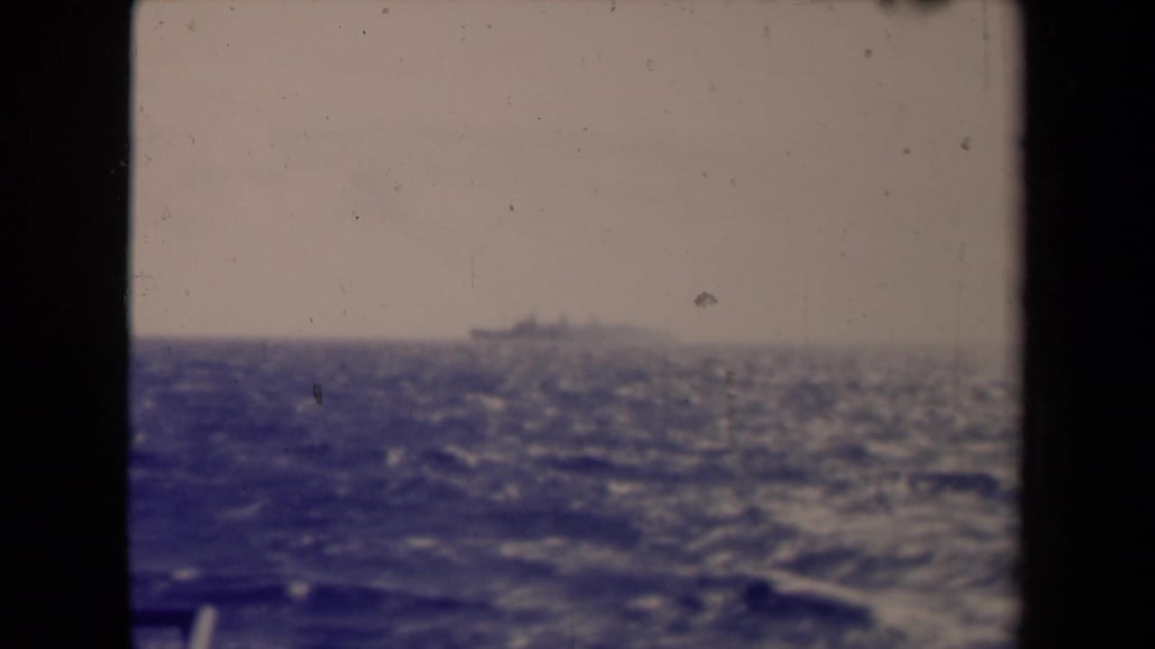 The final 1945 France 8mm frame shows a distant ship over rough blue water under a pale sky.
