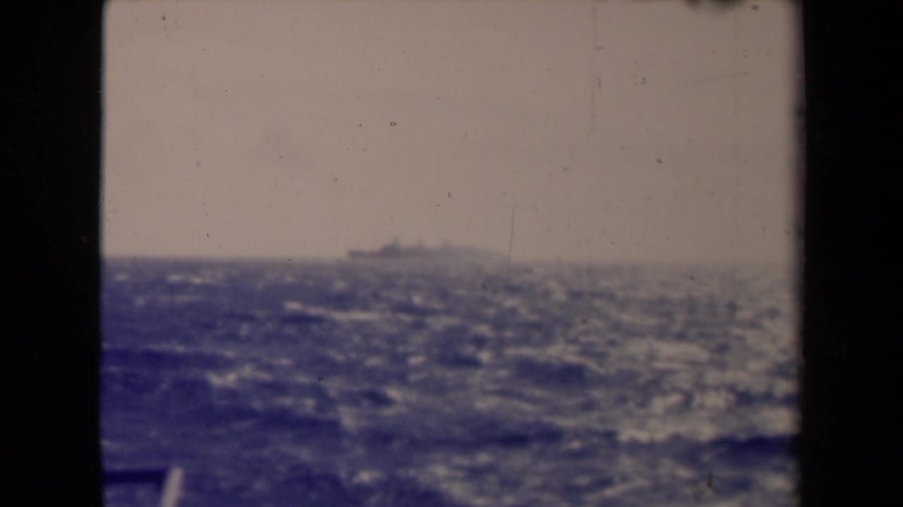 Distant ship above choppy water, seen through a divided dark frame.