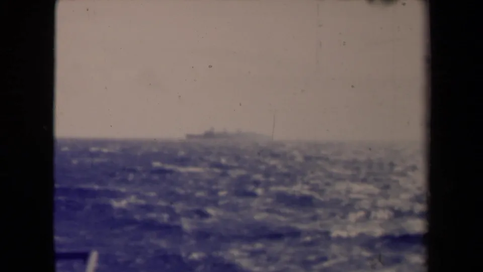 France 1945 8mm view of a distant ship on the horizon, with rough sea below and dark window framing at the sides.