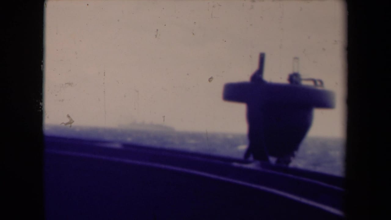 Dark ship structure silhouetted against a hazy sea horizon.