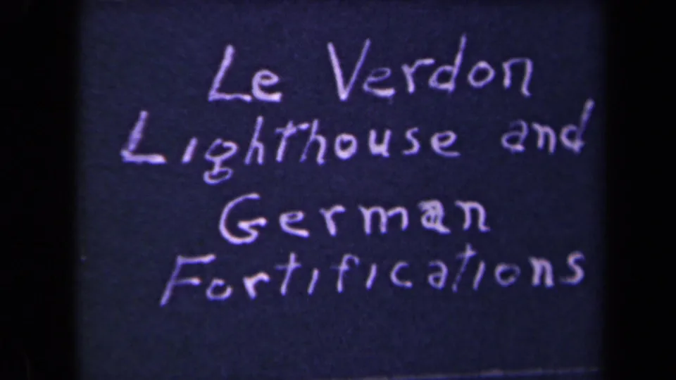 Repeated title-card frame naming Le Verdon lighthouse and German fortifications on dark 8mm film.