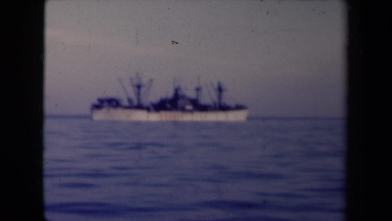 Large ship seen farther right on a calm horizon line.