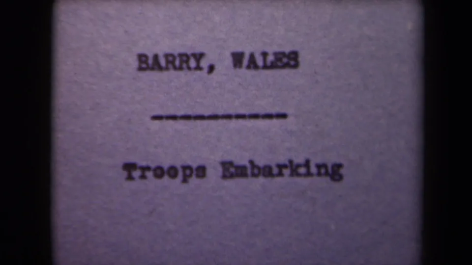 A soft, purple-tinted title card shows Barry, Wales and Troops Embarking within dark film borders.