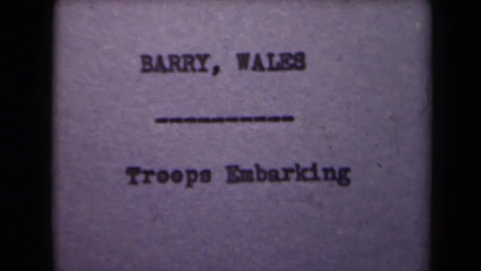 1945 8mm title card associated with France, showing "BARRY, WALES" and "Troops Embarking" in soft typewritten text.