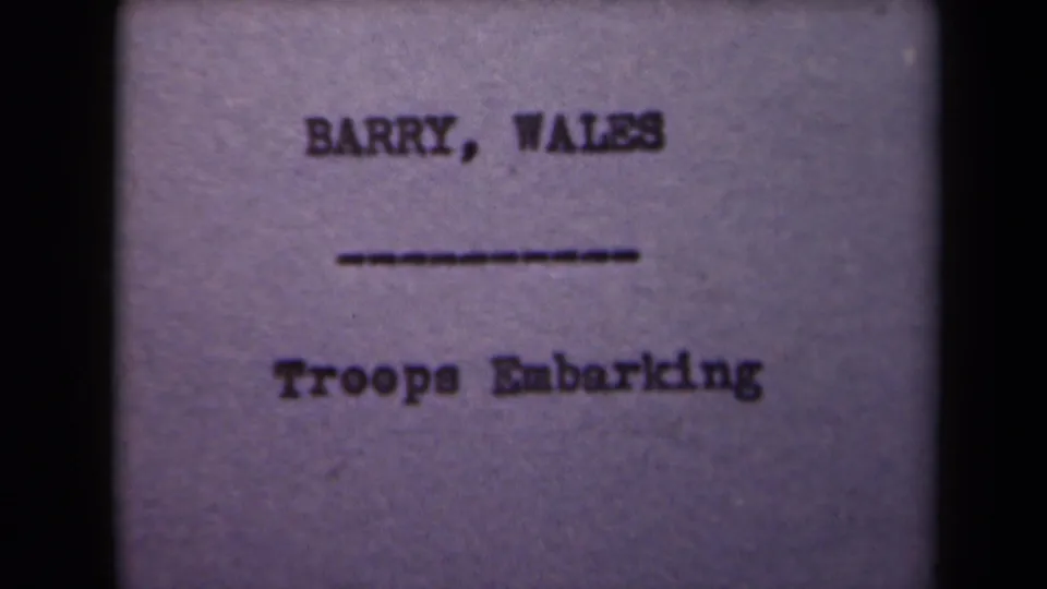 Soft 8mm frame of the same title card, with "BARRY, WALES" over a dashed line and "Troops Embarking" below.