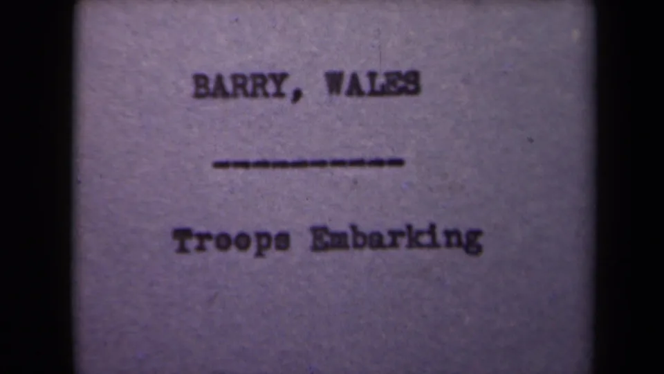 Final sampled 8mm frame of the troop embarkation title card, with the text still centered and slightly blurred.