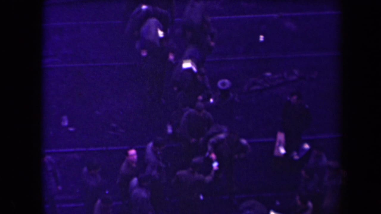 High-angle view of people walking in a line, several carrying bags or packs.