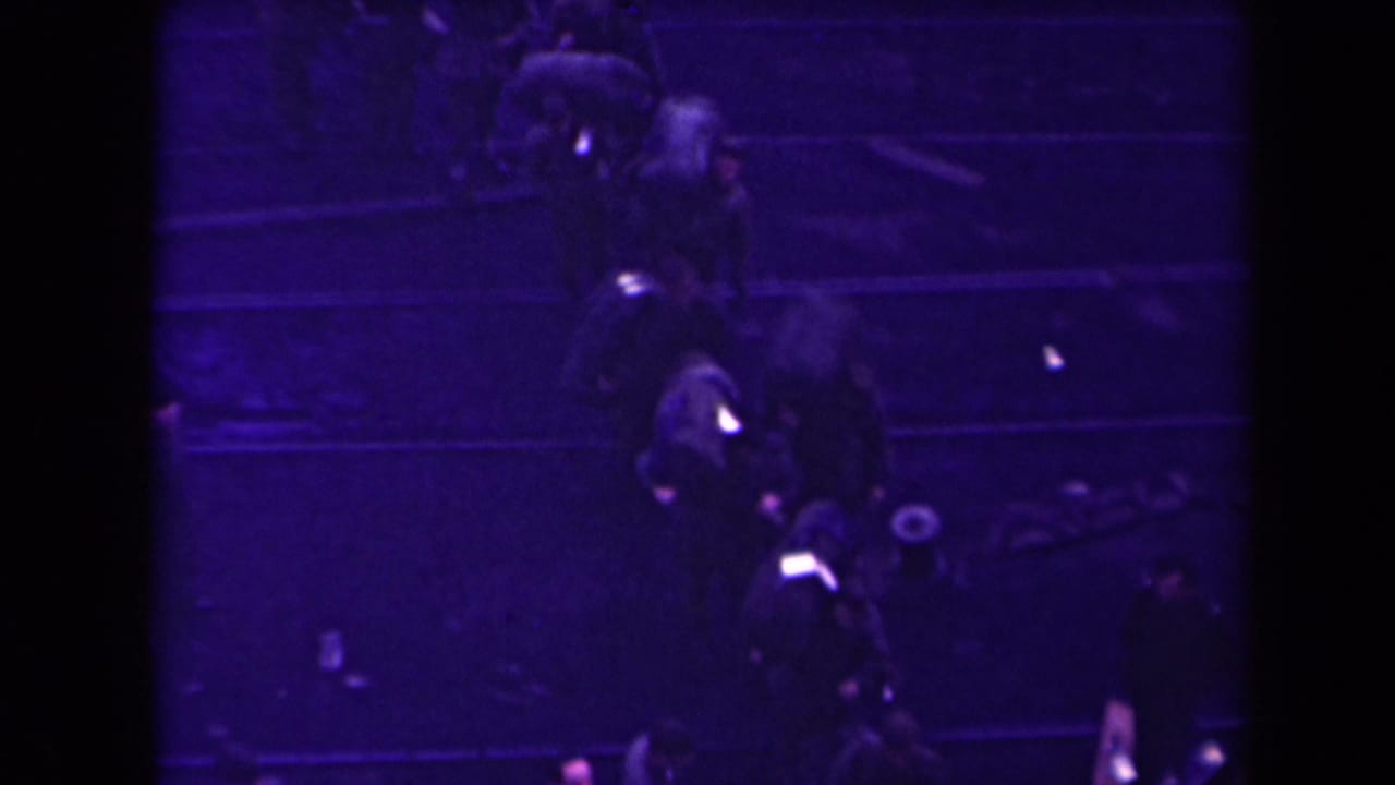 People continue along a dark route, with several figures carrying visible bags.
