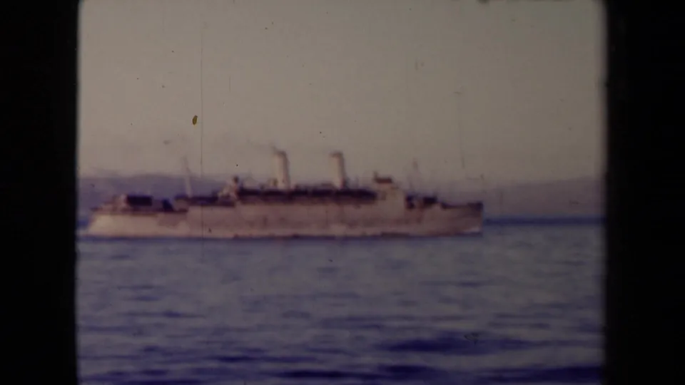 A large steamship passes across calm coastal water in France 1945 metadata context, with twin funnels and a soft shoreline behind it.