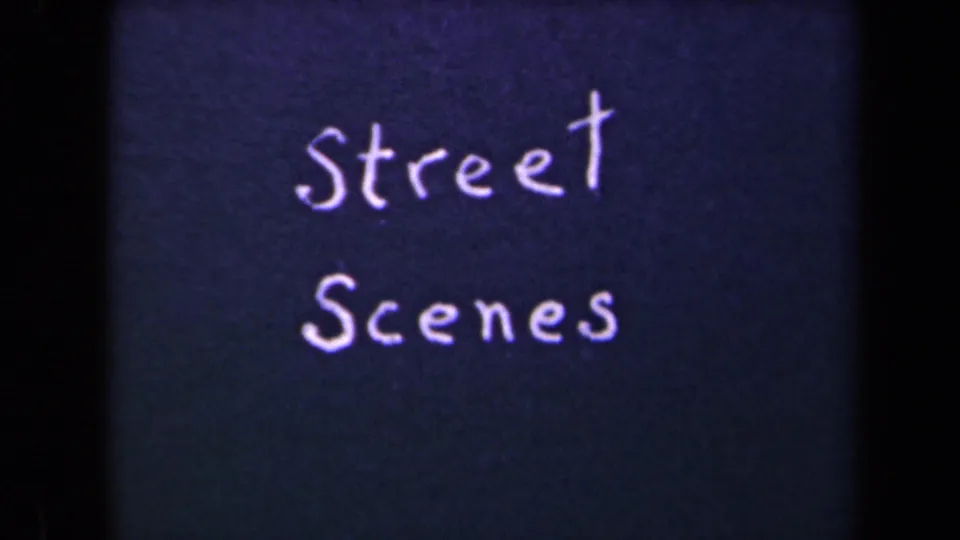 A second view of the handwritten Street Scenes title card, with bright lettering, dark blue background, and visible 8mm frame edges.