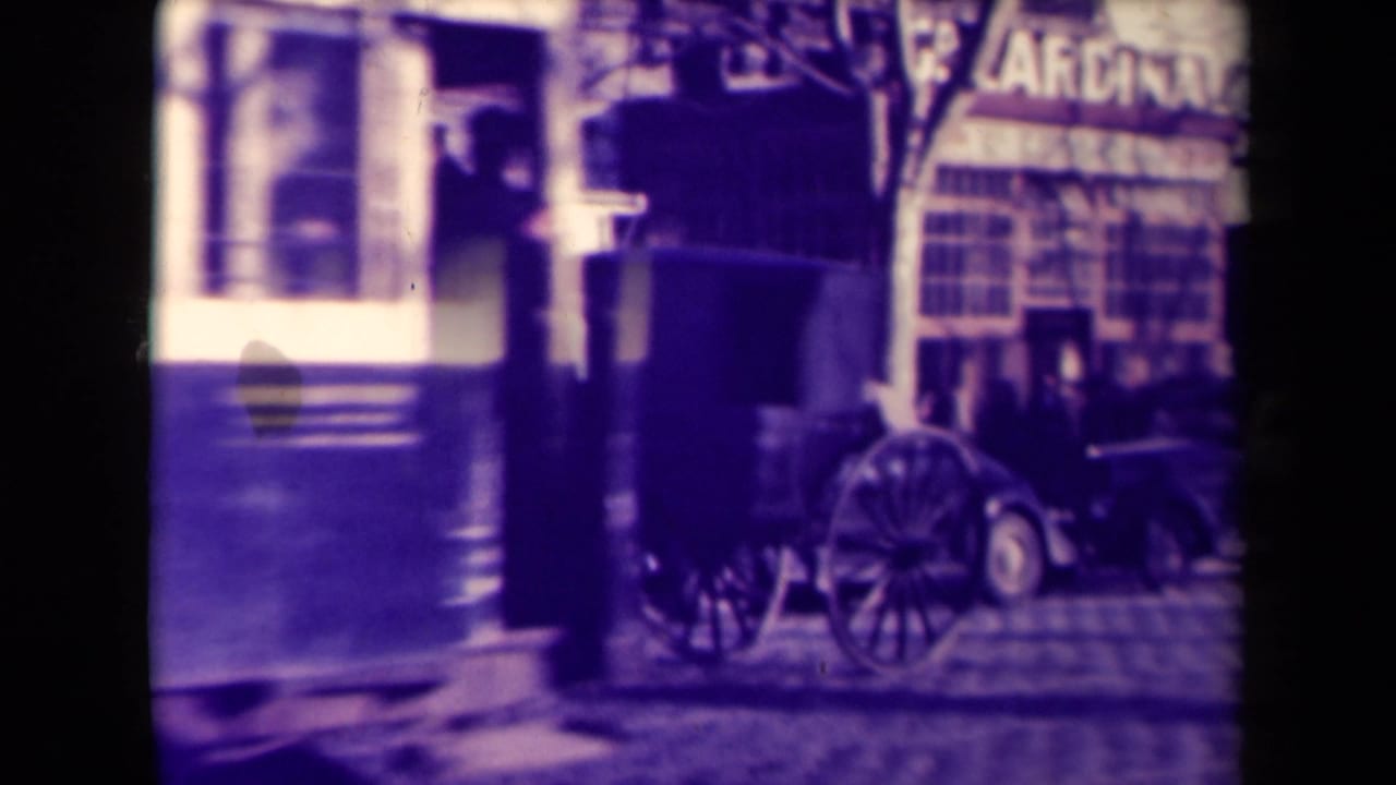 A tram moves through a 1945 French street scene beside a horse carriage, parked automobile, storefront awnings, and pedestrians.