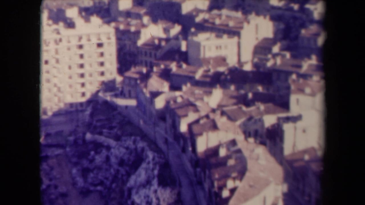 Elevated view over pale apartment buildings and clustered rooftops.