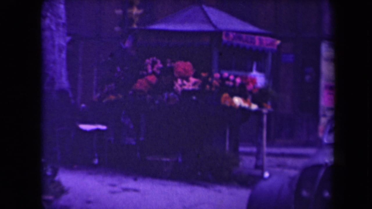 Dark stall and alley wall with goods under a canopy.