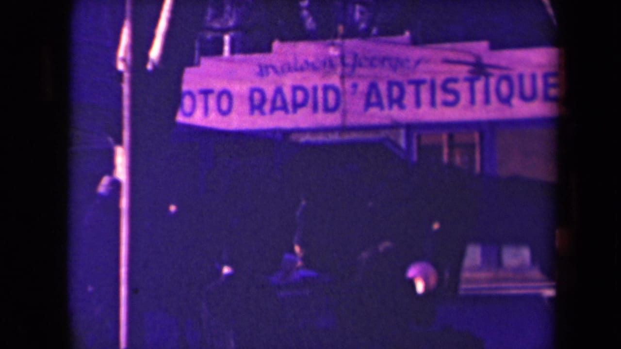 Street view with a large PHOTO RAPID ARTISTIQUE sign above dark figures and shopfront shadows.