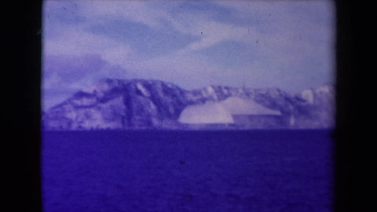 Open sea in front of distant snow or ice-covered landforms.