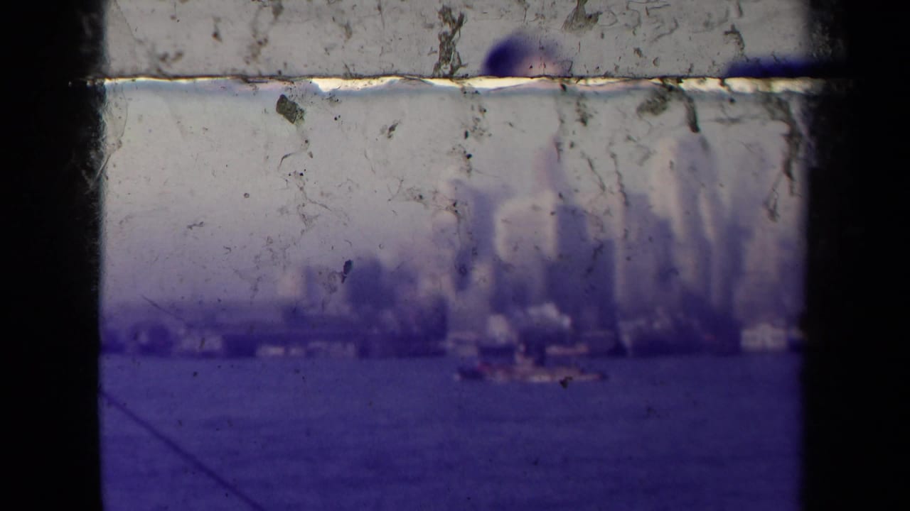 Hazy skyline across water seen through dark film-frame borders.
