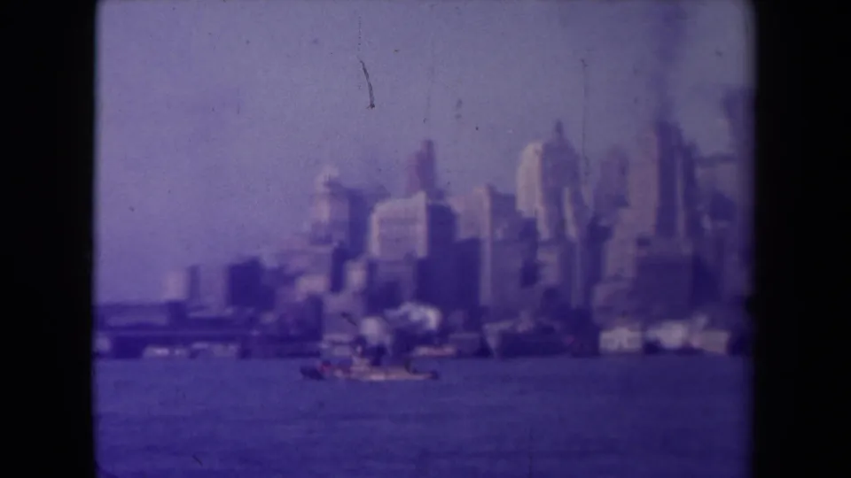 Purple-tinted 8mm frame showing a French urban waterfront skyline, small boats, and a distant span across the water.