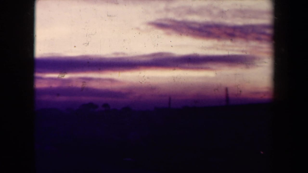 Purple and pink sunset clouds above a dark silhouetted horizon.