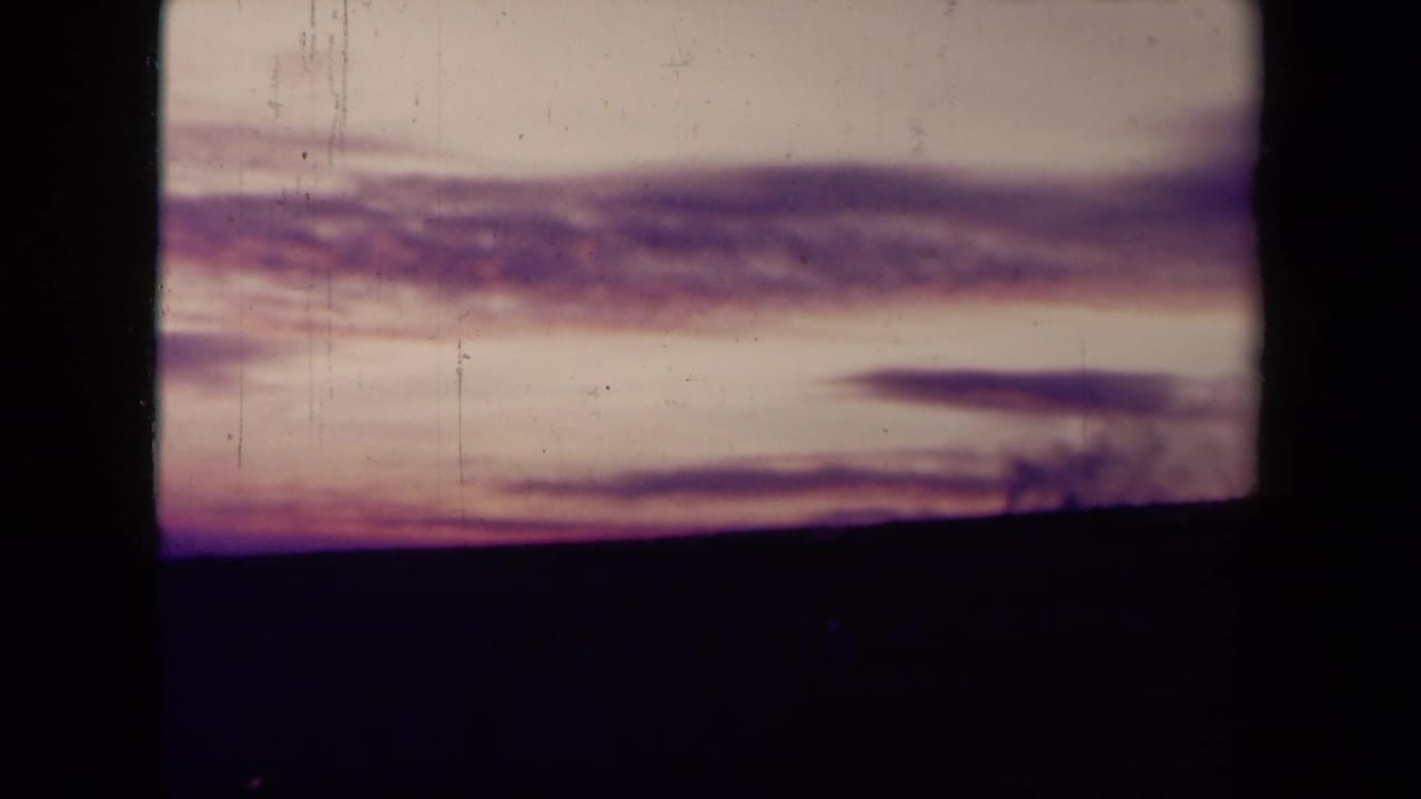 Sea sunset with layered clouds and a dark shoreline or horizon band.