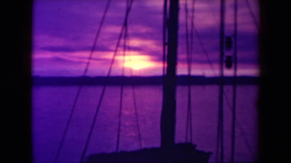 1945 France 8mm frame of a soft purple ocean sunset viewed from a sailboat deck or cabin area.