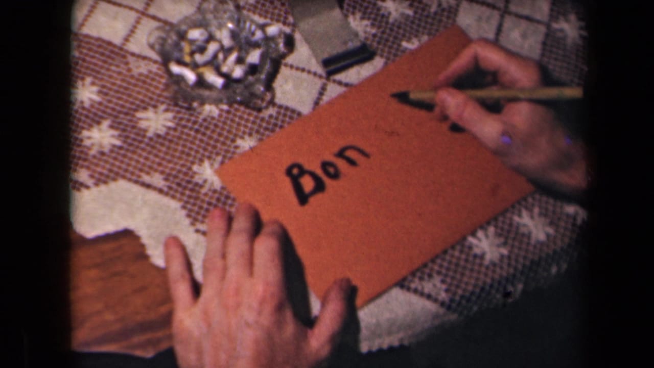 The completed word Bon is shown on a brown envelope as the writing hand lifts the pen in 1945 French 8mm footage.