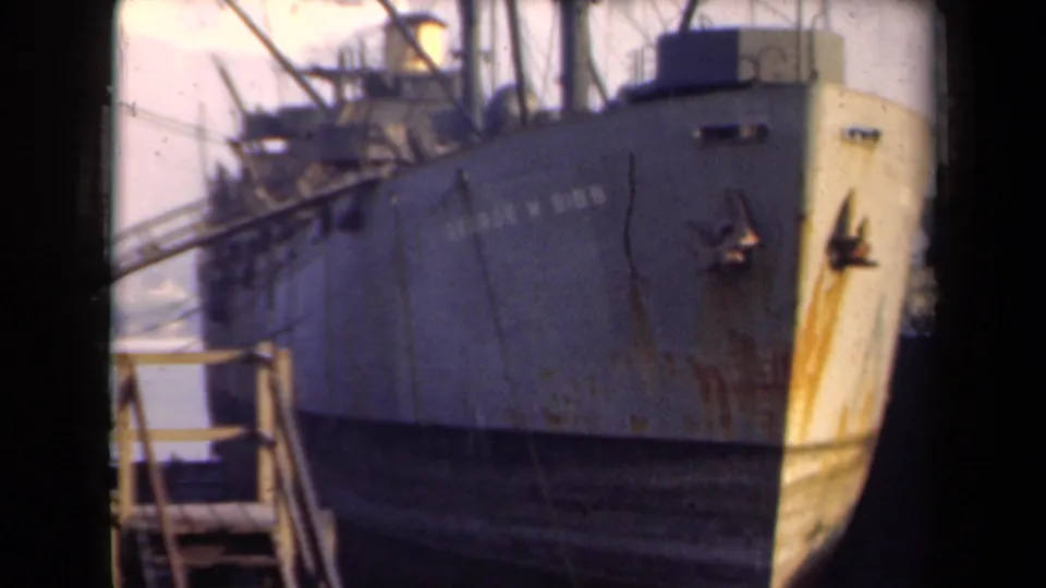 Final 1946 Netherlands frame holds on the docked George W. Gibbs bow, showing aged paint, rust, and port structures around it.