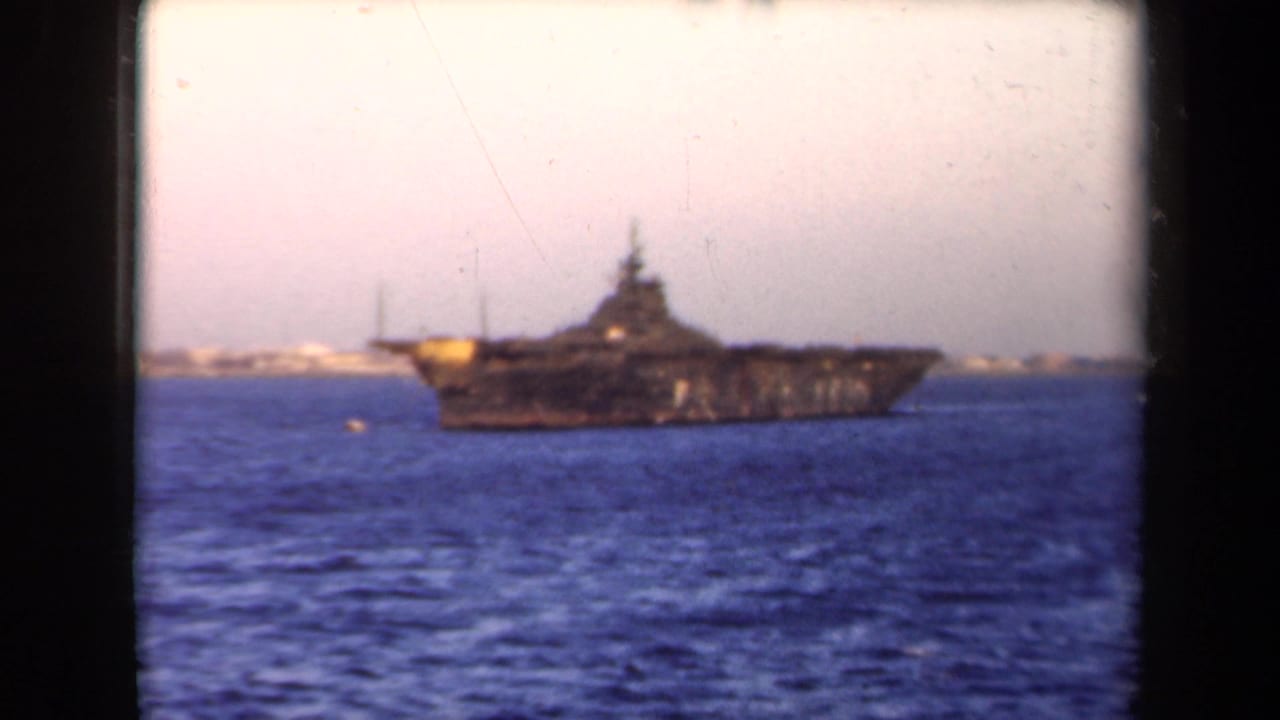 1946 Netherlands 8mm frame showing a large naval-looking vessel on blue water with a distant coastal background.