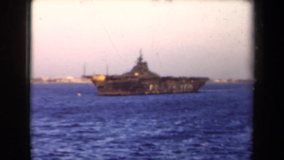 1946 Netherlands 8mm frame showing a large naval-looking vessel on blue water with a distant coastal background.