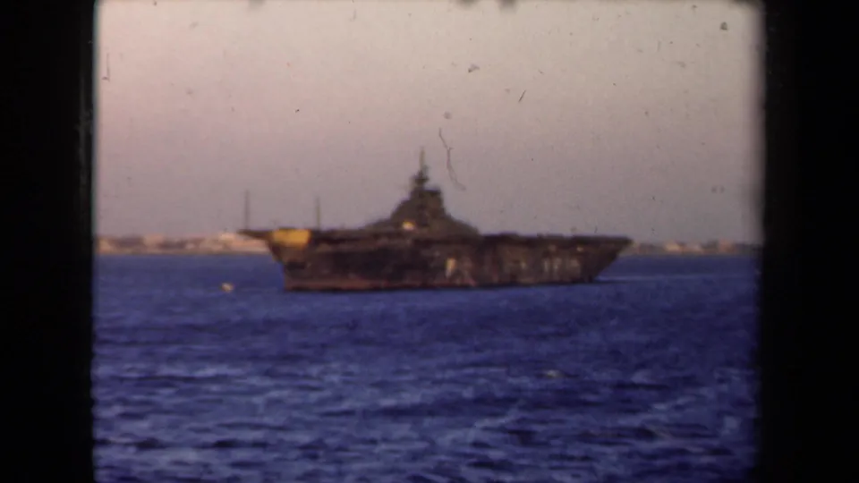 1946 Netherlands 8mm frame of a large vessel viewed from a distance across water, with soft focus and visible film wear.