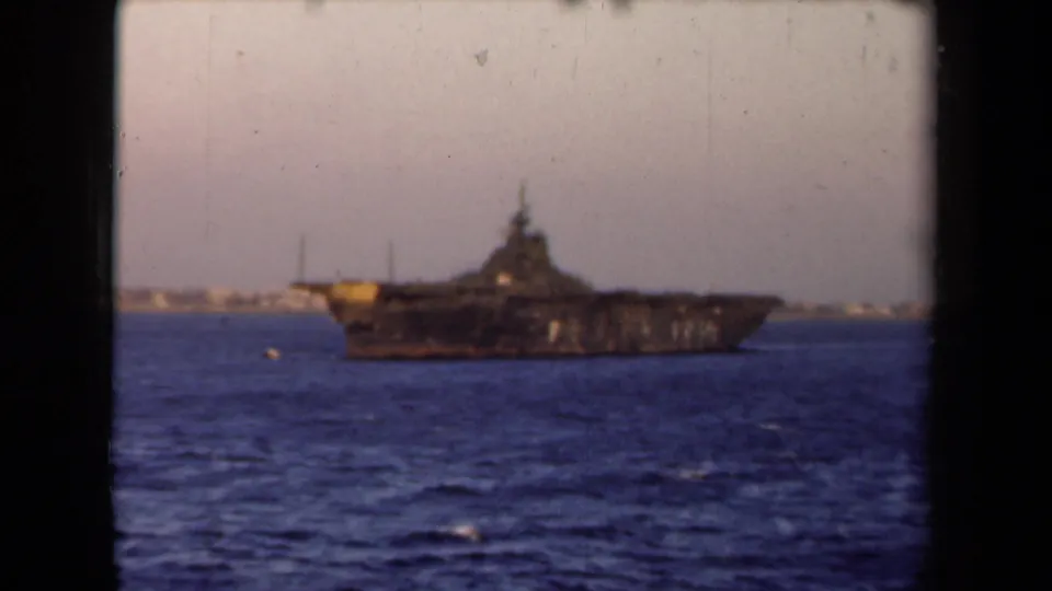 1946 Netherlands 8mm frame showing the large ship in profile on open water, with a faint shoreline beyond.