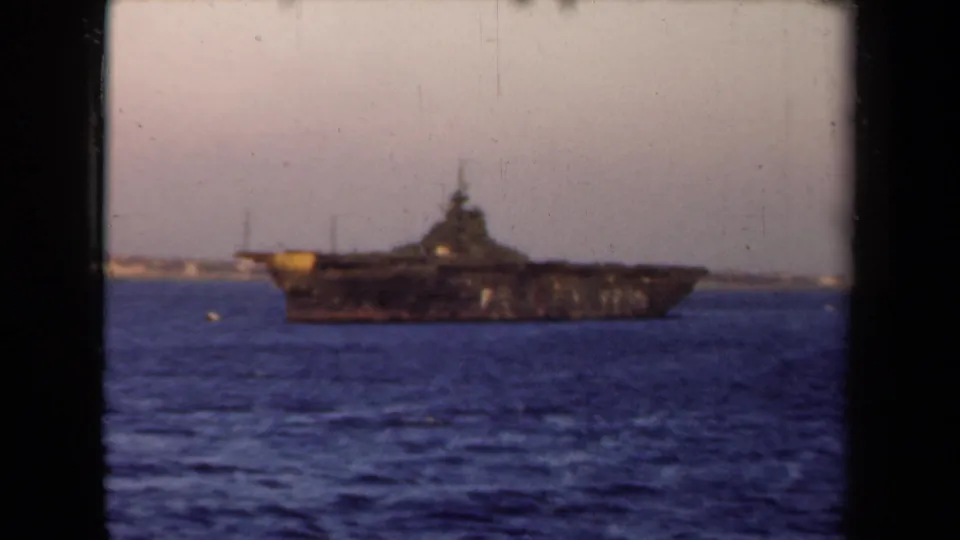1946 Netherlands 8mm view of a distant dark naval ship, with grain and gate borders visible.