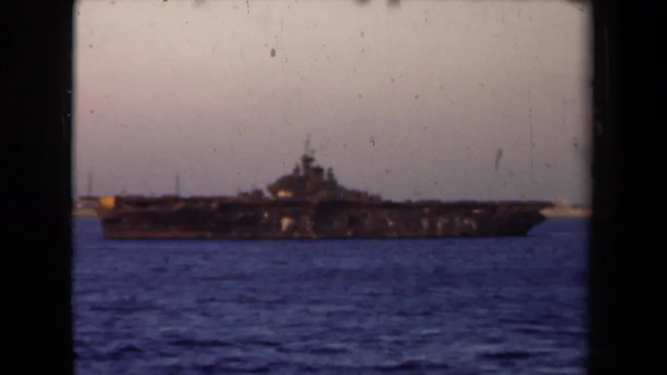 1946 Netherlands frame showing a dark naval vessel offshore, framed by black 8mm film borders.