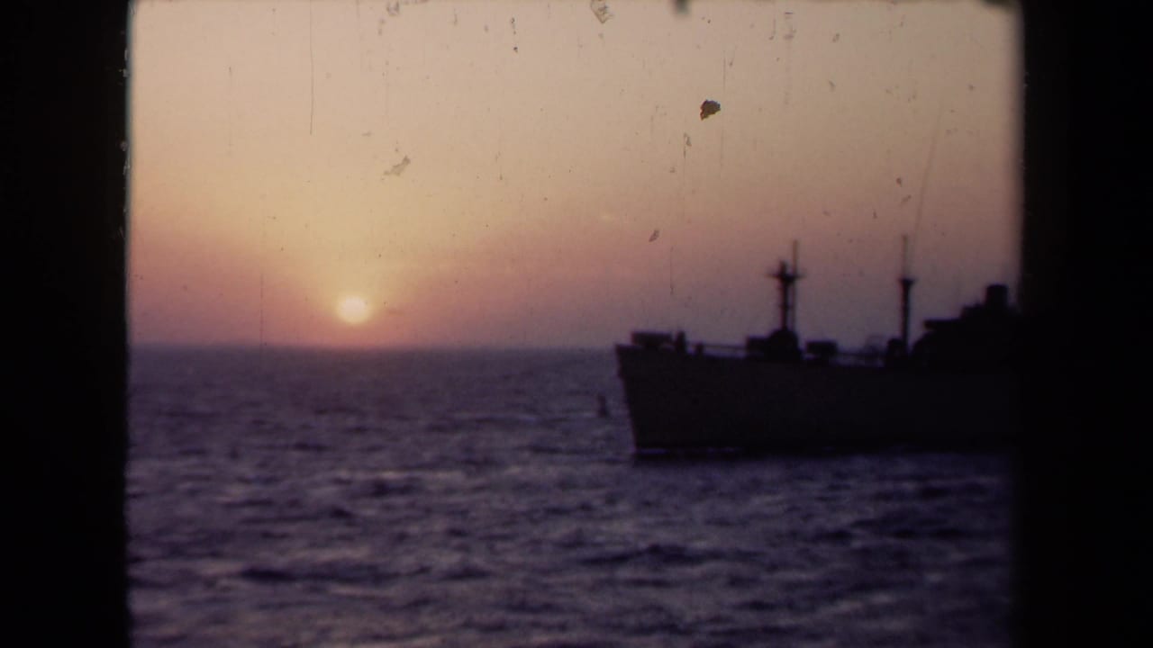 1946 Netherlands 8mm frame showing a dark ship silhouette on choppy water beneath a pink-purple sunset sky.