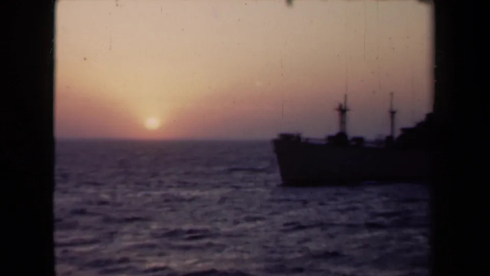 1946 Netherlands 8mm frame with a ship silhouette at right, choppy sea, and sunset light along the horizon.