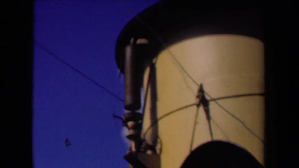 Close 8mm frame of the vessel funnel, crossing wires, and dark lower structure in the Netherlands maritime footage.
