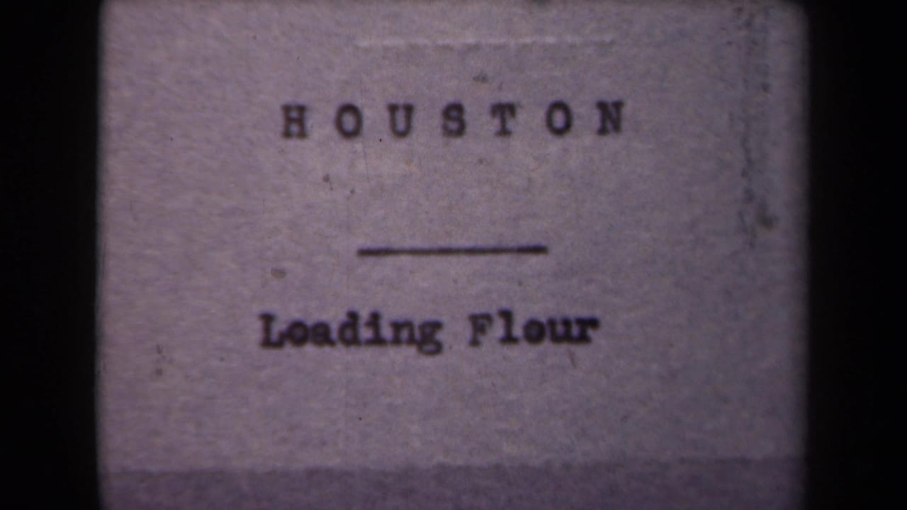 1940s 8mm title card with the words Houston and Loading Flour, shown on a softly focused film frame.