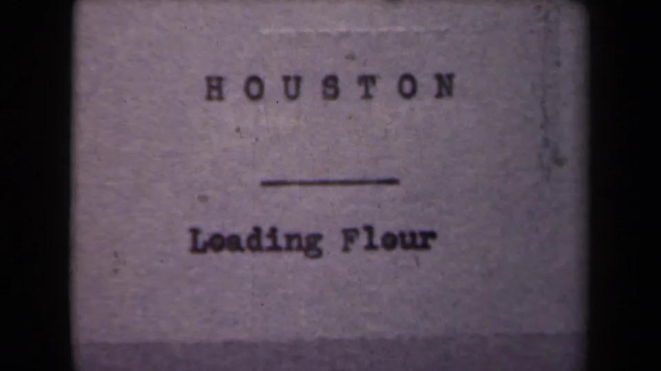 1940s 8mm title card with the words Houston and Loading Flour, shown on a softly focused film frame.
