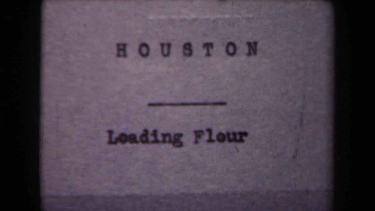 Repeated 8mm title card for the flour-loading scene, with Houston printed above Loading Flour.