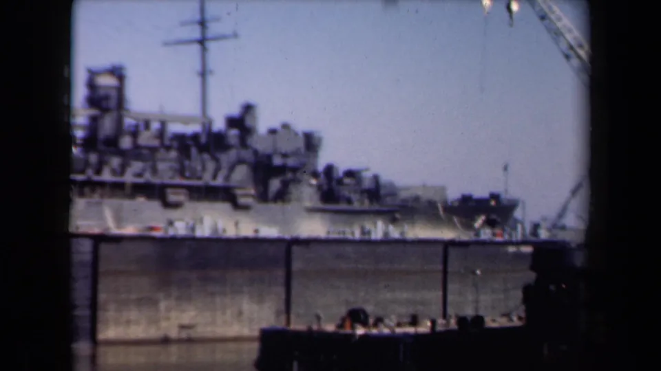 Final 1946 Netherlands harbor frame showing a large ship alongside the quay, with crane fragments and dark foreground shapes at the edge.
