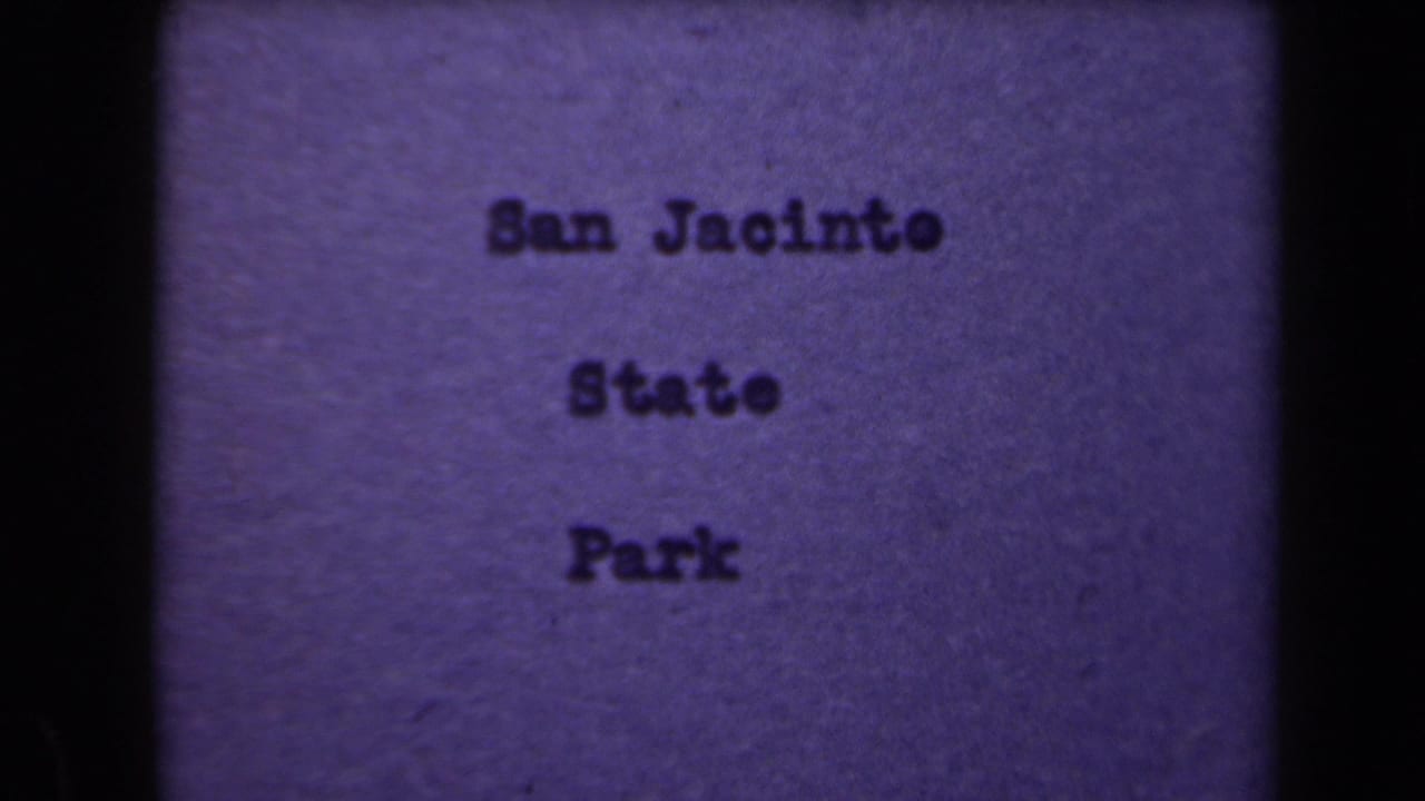 1940s 8mm title card appears to identify San Jacinto State Park, shown with dark film borders and purple color shift.