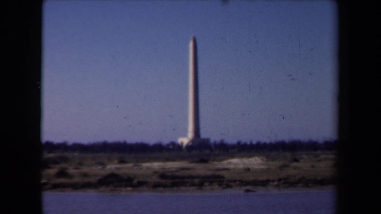 A distant waterfront monument remains centered across the water in a 1946 Netherlands home-movie frame.