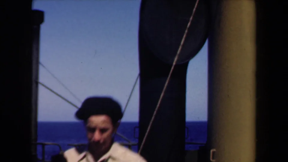 Close 1946 Netherlands home-movie frame of the sailor partly blurred near ship structures with the ocean visible behind.