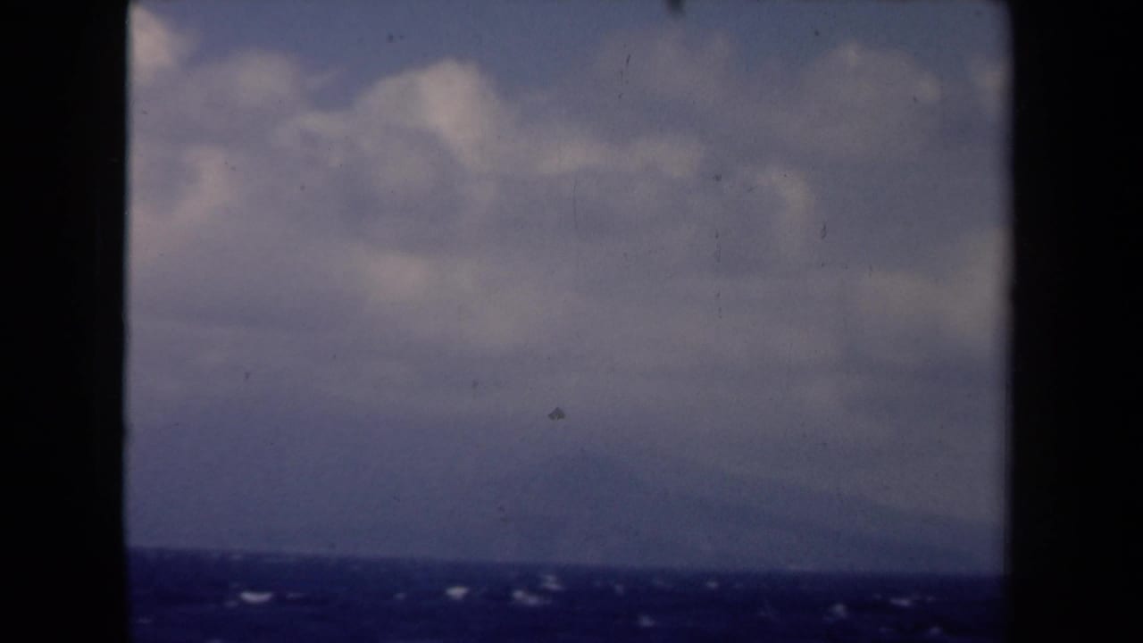 1946 Netherlands 8mm seascape with muted clouds, dark blue water, and a faint low horizon or landform in the distance.