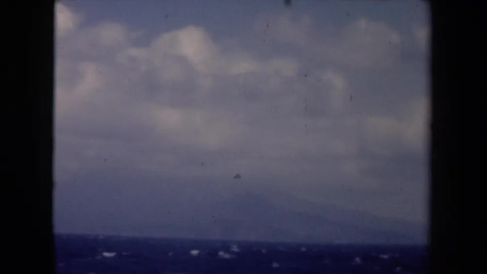 1946 Netherlands 8mm seascape with muted clouds, dark blue water, and a faint low horizon or landform in the distance.