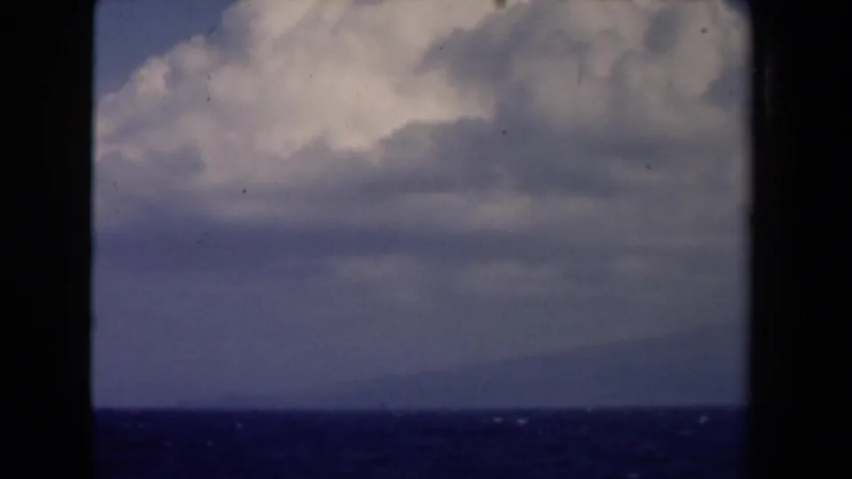 1946 Netherlands 8mm sea view with layered clouds, a low horizon, and dark window-like borders around the frame.