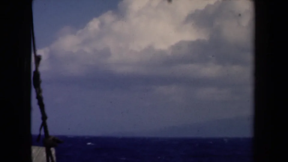 1946 Netherlands vessel-side view of ocean and clouds, with a dark divider and rope-like line visible near the frame edge.