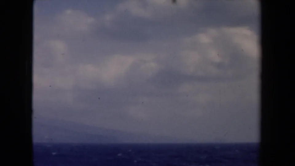1946 Netherlands 8mm frame of open sea below a soft cloudy sky, bordered by dark boat structure.