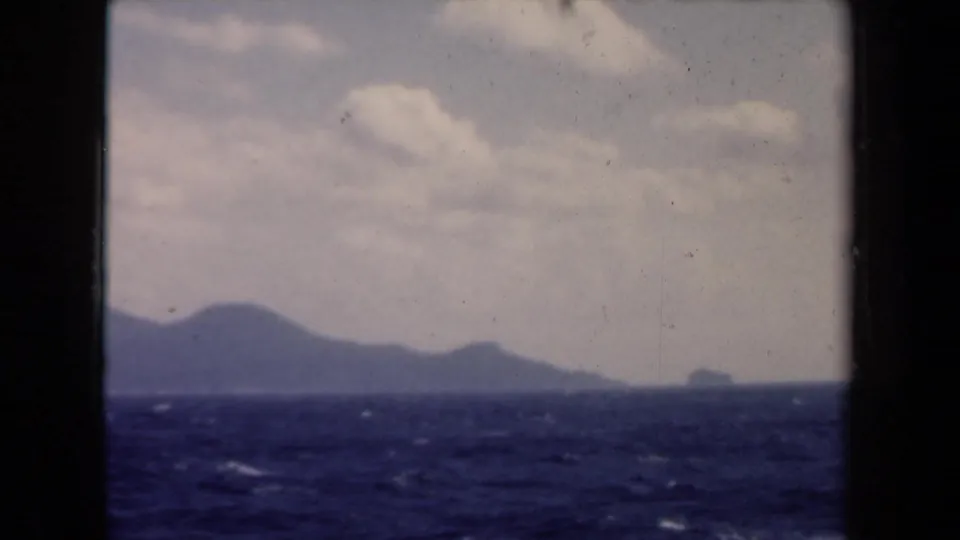 1946 Netherlands boat-view footage showing choppy water, cloud cover, and a hazy mountainous coastline.